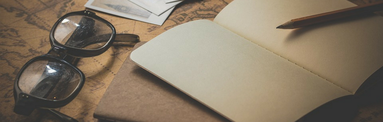 old fashioned photo of notepad pencil and pair of glasses