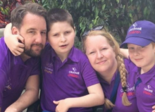 sebastian with his mum dad and brother wearing purple polo tshirts