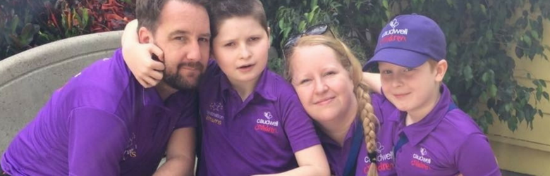 sebastian with his mum dad and brother wearing purple polo tshirts