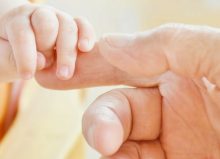 baby and parent touching hands