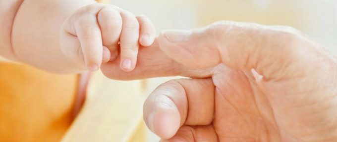 baby and parent touching hands