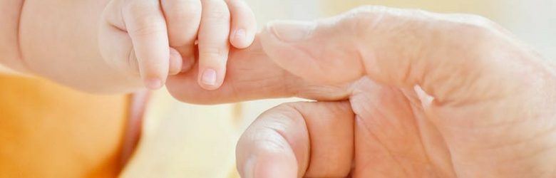 baby and parent touching hands