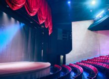 empty theatre seats and stage with dramatic lighting