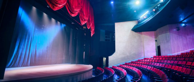 empty theatre seats and stage with dramatic lighting