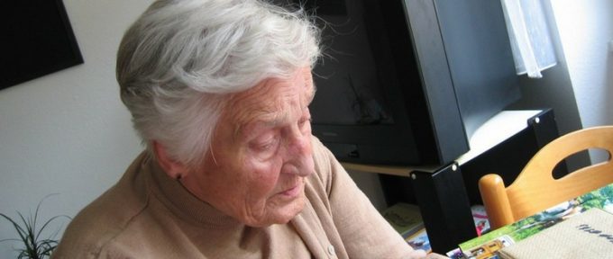 elderly person with dementia looking down, waiting for his long-distance caregivers