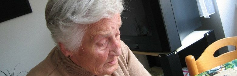 elderly person with dementia looking down, waiting for his long-distance caregivers