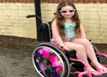 amelia wearing sunglasses smiling in her wheelchair