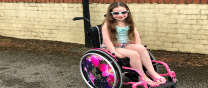 amelia wearing sunglasses smiling in her wheelchair