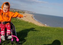 summer waving her arms in her wheelchair