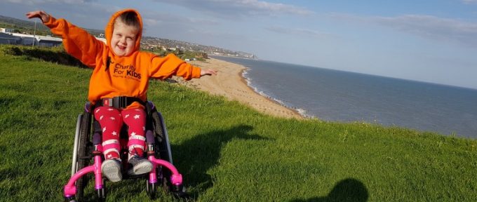 summer waving her arms in her wheelchair