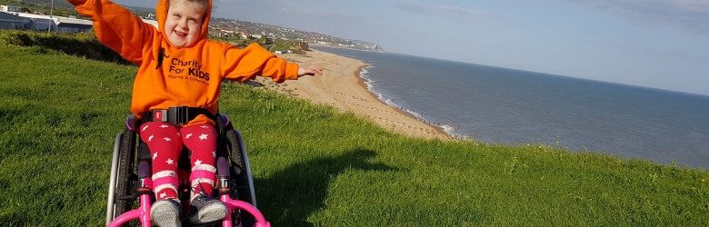 summer waving her arms in her wheelchair