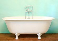 bath tub on wooden flooring in front of painted wall