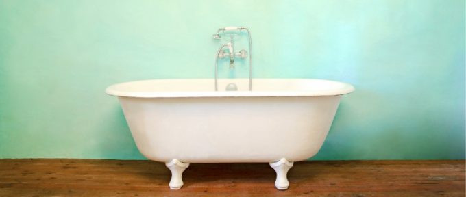 bath tub on wooden flooring in front of painted wall