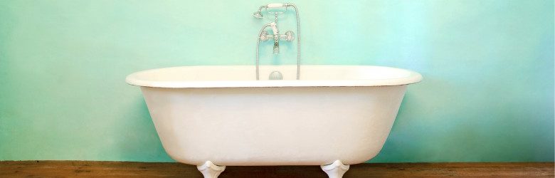 bath tub on wooden flooring in front of painted wall