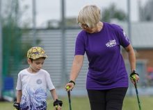 young boy walking with a lady wearing a limbpower tshirt