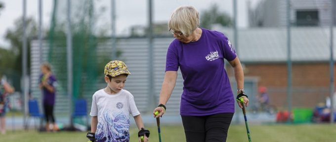 young boy walking with a lady wearing a limbpower tshirt