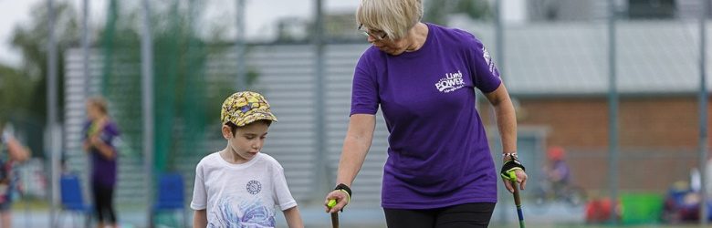 young boy walking with a lady wearing a limbpower tshirt