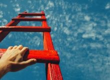 hand reaching out for ladder towards blue sky