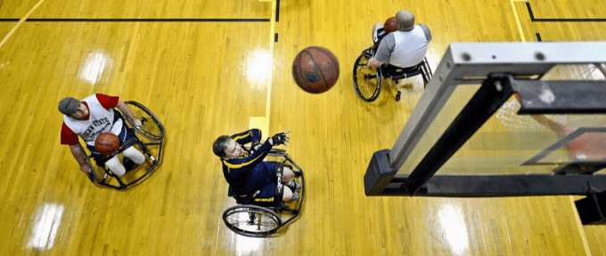 3 men playing wheelchair basketball