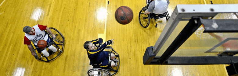 3 men playing wheelchair basketball