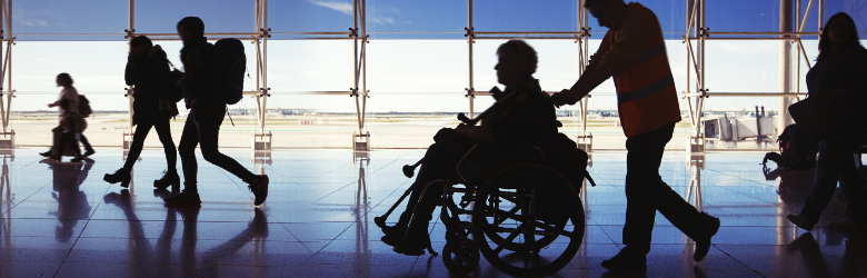 accessible travel - silhouette of man in wheelchair at airport