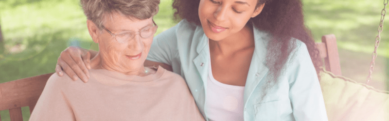 person reading with carer outside